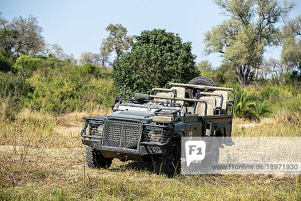 A safari vehicle  parked in the African wilderness.