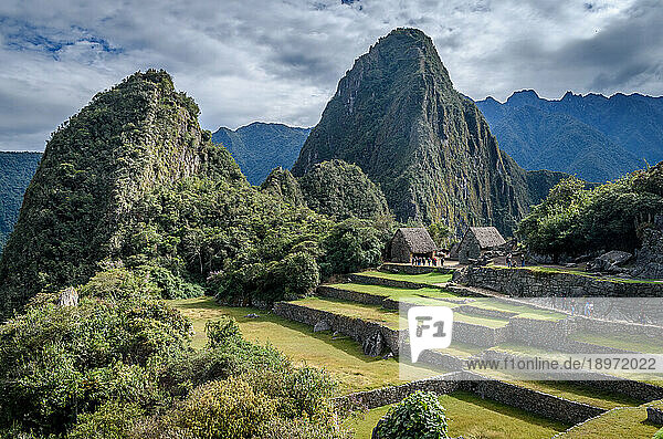 The path to Machu Picchu  the high mountain capital of the Inca tribe  a 15th century citadel site  buildings and view of the plateau and Andes mountains.