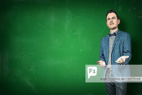Mann im Jackett unterrichtet auf einer grünen Kreidetafel