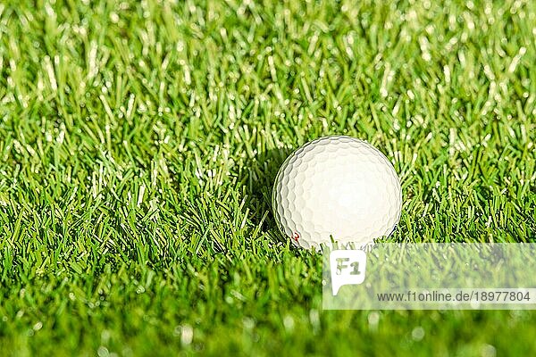 Golfball auf Astro Rasen bei hellem Tageslicht