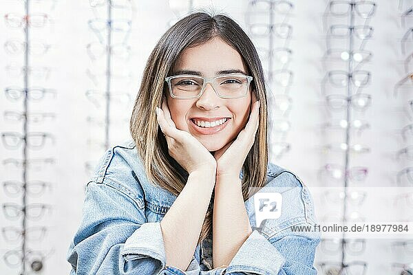 Porträt einer glücklichen jungen Frau mit Brille in einem Optikgeschäft. Attraktives Mädchen modelliert Brille in einem Brillengeschäft
