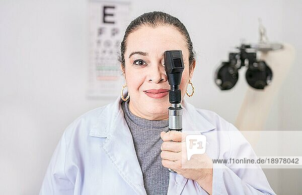 Porträt einer Optometristin mit Ophthalmoskop im Labor. Lächelnder Augenarzt  der ein Ophthalmoskop im Labor hält