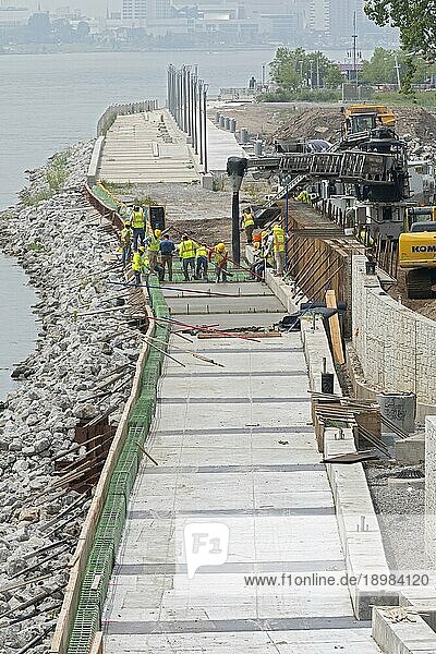 Arbeiter gießen Zement  um einen Abschnitt des Detroit Riverwalk auf dem Gelände der ehemaligen Uniroyal Reifenfabrik fertigzustellen. Der Wander und Radweg entlang des Detroit River wurde zum besten Flussweg Amerikas gekürt