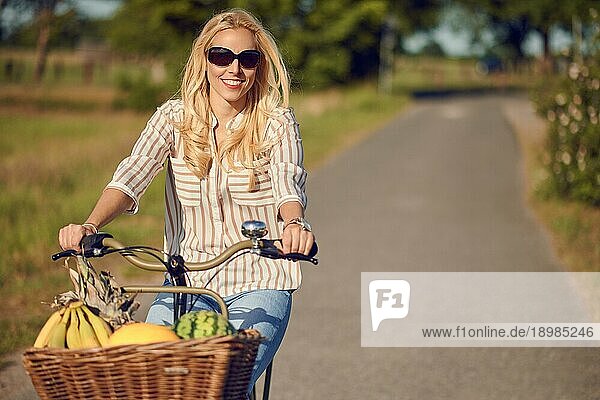 Glückliche Frau beim Fahrradfahren auf dem Lande