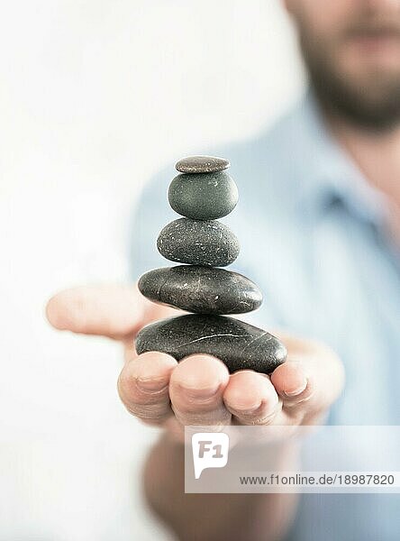 Mann balanciert Steine