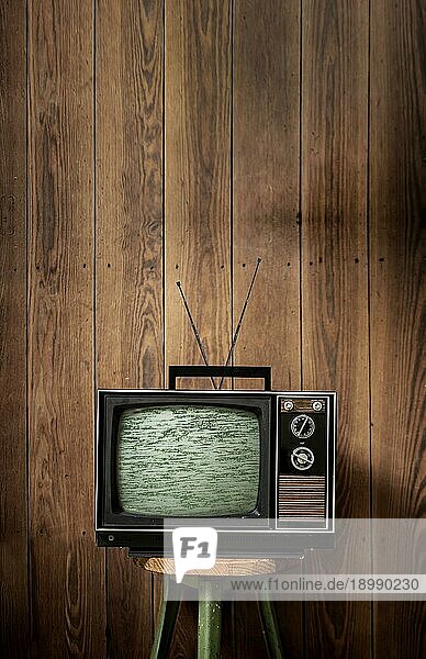 Alter Fernseher vor Holzwand