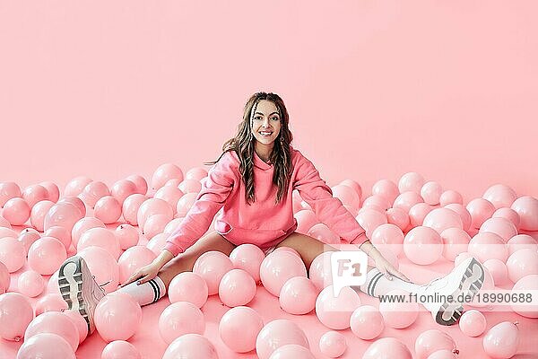 Junge trendige Frau posiert mit rosa Luftballons auf rosa Hintergrund. Pop Art. Celebraion  festlich  Spaß Konzept