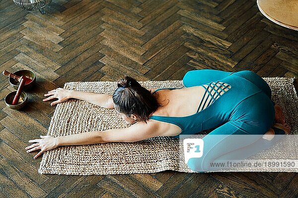 Junge schlanke Frau übt Yoga  indem sie die Kinderstellung zu Hause einnimmt. balasana. Harmonie  Meditation  Entspannung  gesunder Lebensstil Konzept