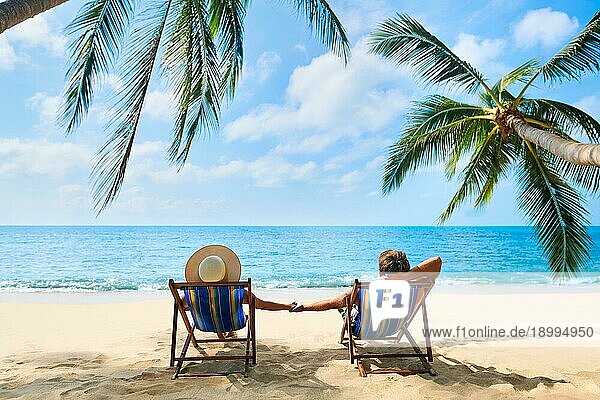 Paar am Strand entspannen und genießen Sie das schöne Meer auf der tropischen Insel. Sommer Strandurlaub Konzept