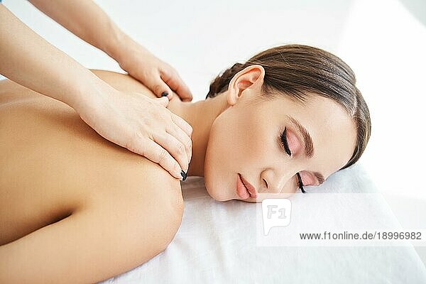 Close up Porträt der jungen Frau genießt entspannende Rückenmassage im Spa Salon. Körperpflege  Erholung Konzept