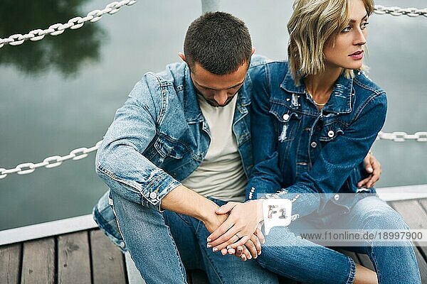Schöne modische Paar posiert auf Fluss Brücke tragen Denim Jeans. Liebe  Gefühle und Beziehung Probleme Konzept