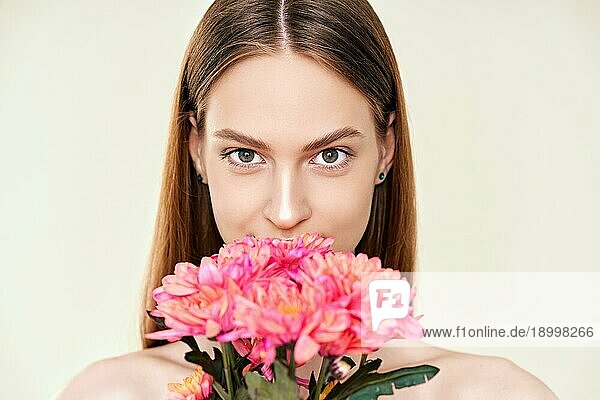 Porträt der schönen jungen Frau mit Blumen auf Studio Hintergrund. Weibliche Schönheit  Spa  saubere Haut Konzept