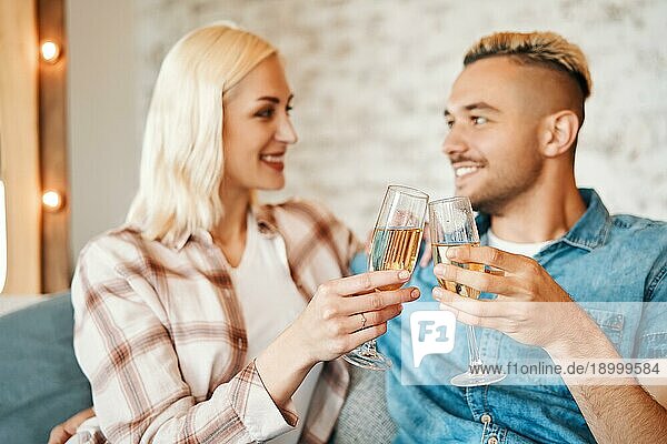 Junges Paar stößt mit Weingläsern zu Hause an. Beziehung  Feier  Dating Konzept