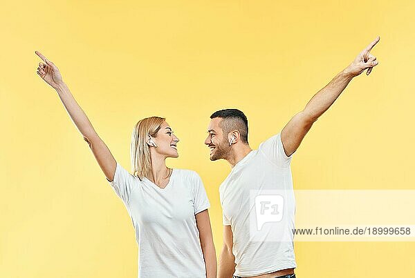 Glückliches Paar tanzen oder feiern Erfolg mit Händen nach oben Geste auf gelbem Hintergrund. Sieg  Triumph und Emotionen Konzept
