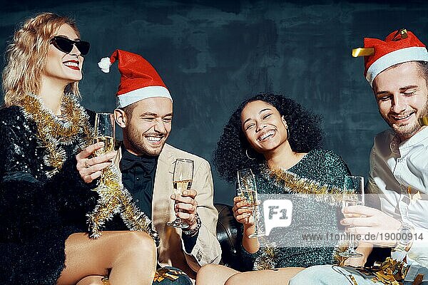 Gruppe von glücklichen lächelnden Freunden feiern Silvester zusammen  Spaß haben und trinken Champagner. Feiertage  Feier  Nachtleben und Konzept