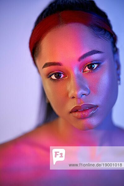 Closeup Porträt der hübschen afrikanischen amerikanischen Frau in hellen Neonlichtern posiert auf Studio Hintergrund. Mode Foto Konzept