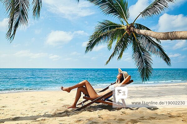 Junge schöne Frau sonnenbaden und entspannen am tropischen Strand. Sommerurlaub Konzept