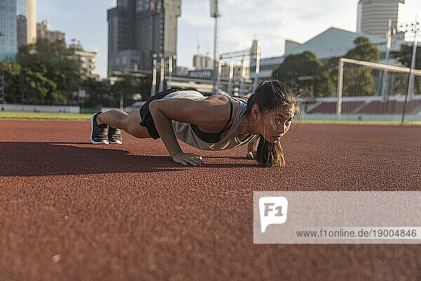 Determined woman exercising on sports field