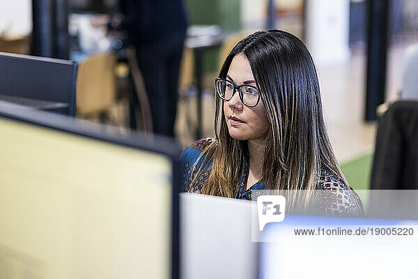 Businesswoman wearing eyeglasses using computer in office