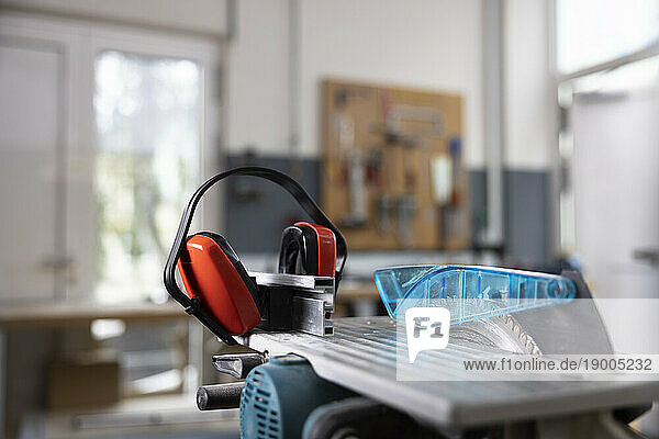 Circular saw and ear protectors in workshop