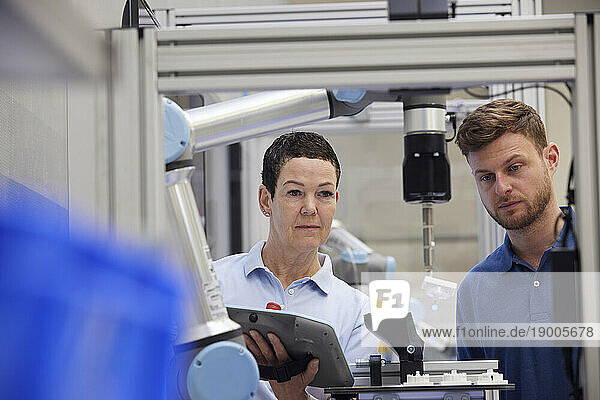 Colleagues working together in modern robotic factory