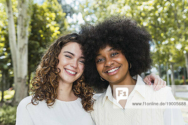 Happy multiracial friends together in park