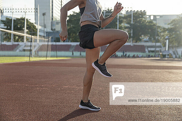 Young athlete warming up for exercise in sports field