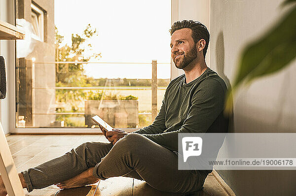 Man sitting with tablet PC on floor