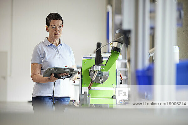 Mature engineer testing machine in robotic factory