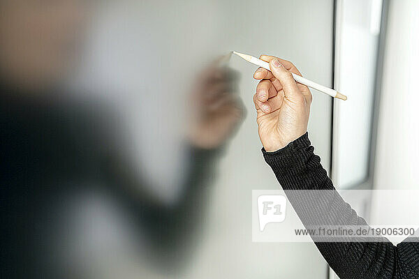 Hand of businesswoman writing on interactive whiteboard with digitized pen