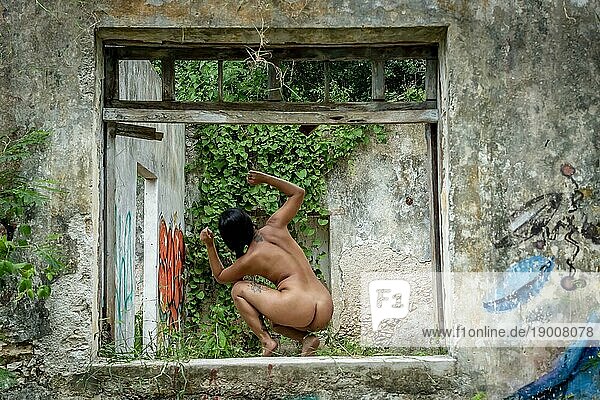 Ein wunderschönes nacktes Latino Modell posiert in einem verlassenen Pueblo in der mexikanischen Provinz Yucatan