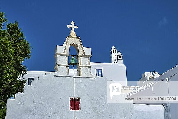 Typischer Glockenturm einer weiß getünchten griechisch orthodoxen Kirche oder Kapelle an einem klaren Sommertag. Traditionelle Architektur auf den griechischen Inseln. Mediterrane Städte. Blauer Himmel  keine Wolken. Bild oben