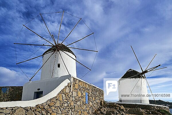 Berühmte Touristenattraktion von Mykonos  Kykladen  Griechenland. Zwei traditionelle  weiß getünchte Windmühlen am Wasser und in der Stadt Chora. Sommer  blauer Himmel  schöne Wolken. Reiseziel  ikonische Ansicht. Frontalaufnahme