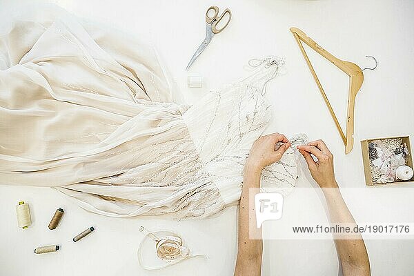 Hohe Winkel Ansicht Modedesigner s Hand arbeiten Kleid weißem Hintergrund. Hohe Auflösung Foto