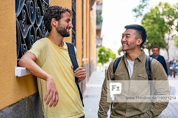 Zwei multiethnische männliche College Freunde in der Stadt lächeln  ein Asiate und ein Weißer