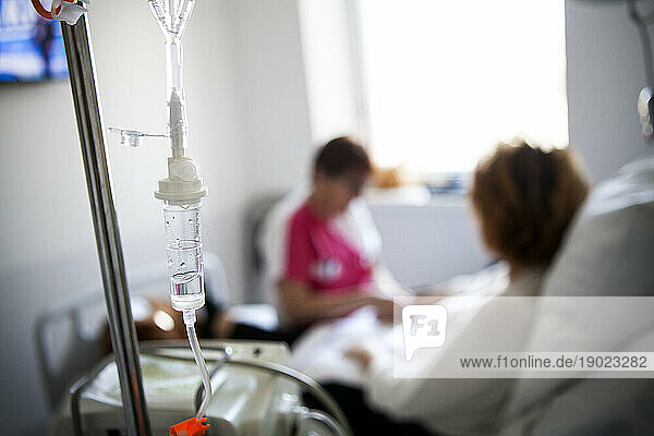 Socio-esthetician giving a cosmetic treatment to a patient during her chemotherapy session.