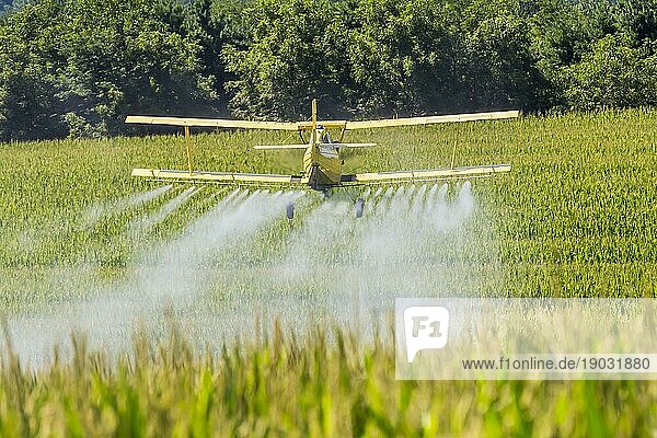 Ein Sprühflugzeug bringt Chemikalien auf einem Feld aus