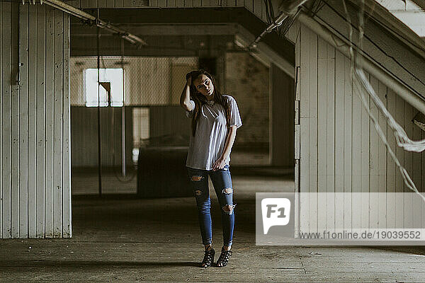 A woman in a white t-shirt in an old derelict factory in maine