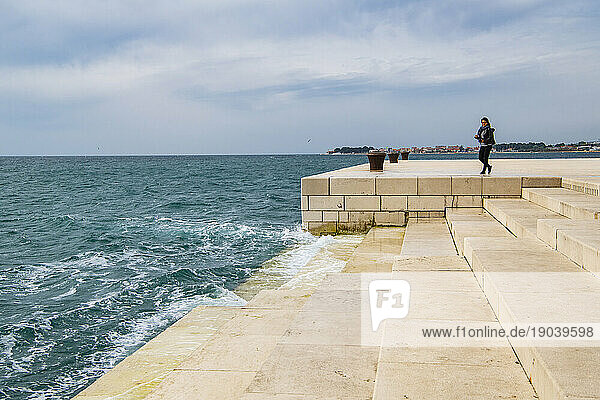 Woman looking at the Sea Organ in Zadar / Croatia