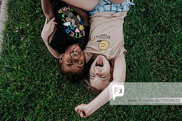 Two girls making goofy faces in grass
