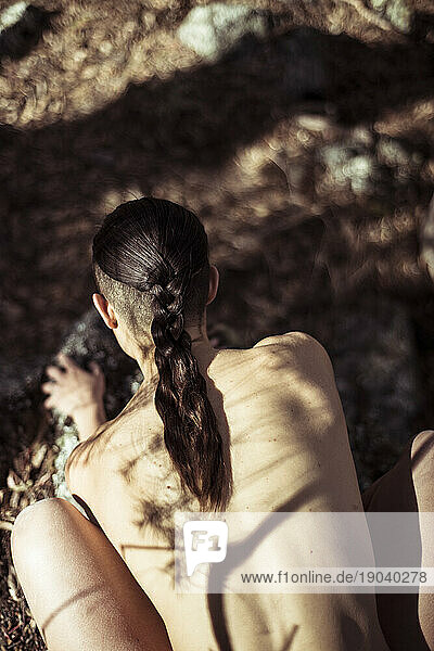 Naked strong back with dappled light in nature
