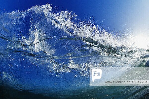 View looking into the sun through a crystal wave from inside the water in Santa Cruz  California.
