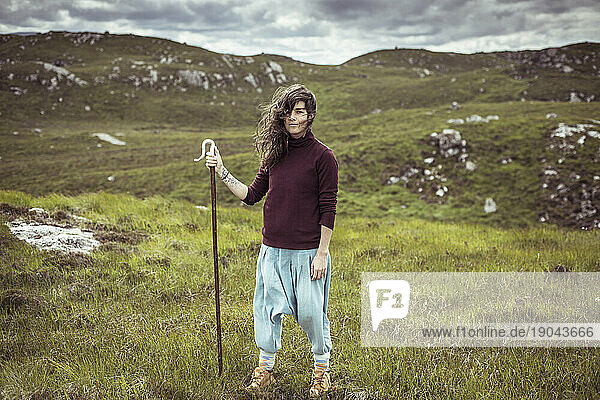 portrait of wild woman with staff in remote mountains