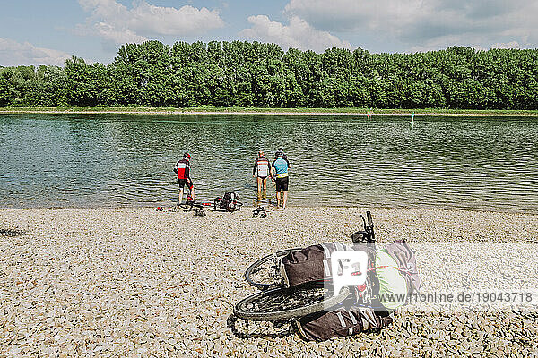 A group of friends cyclists in the water of The Rin river in Germany