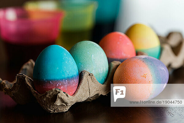Close up of dyed Easter eggs in bright colors drying on a carton.