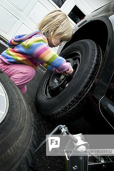 2-3 year old girl changing a flat tire  Cumberland  Maine.