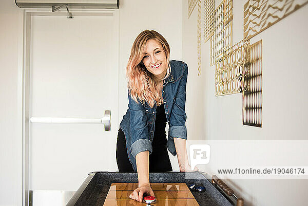 Young woman playing game of shuffleboard