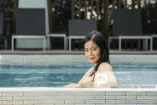 beautiful Thai woman relaxing by the pool