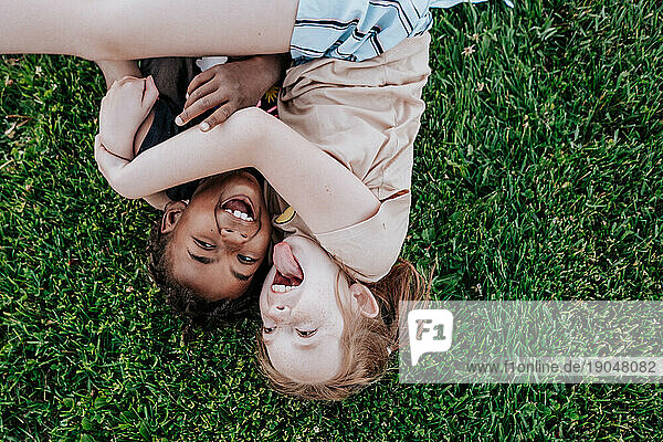 Children laying in grass being silly
