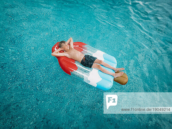 Person floating on red white and blue popsicle swimming pool flo